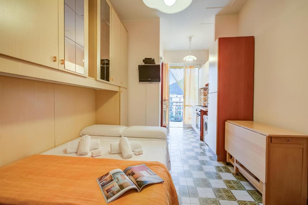 ein Hotelzimmer mit einem Bett mit einem Buch darauf in der Unterkunft Il Rifugio - Town Center - Happy Rentals in Borghetto Santo Spirito