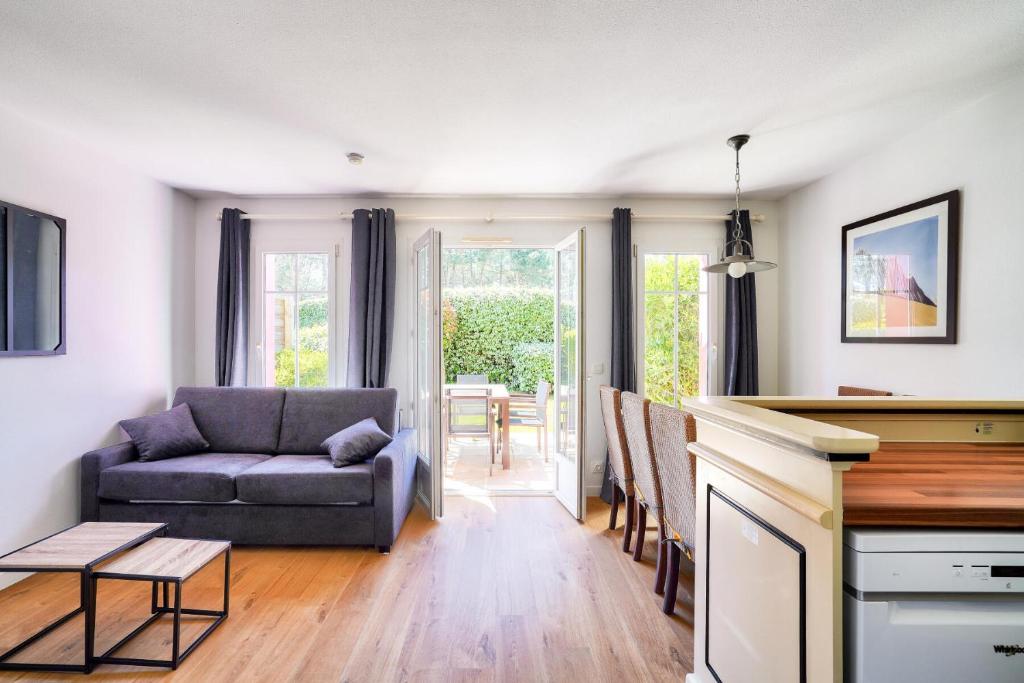 un salon avec un canapé et une table dans l'établissement Les Maisons de Lacanau les Pins - maeva Home - Maison 3 pièces 6 personnes - Sélection MAE-2031, à Lacanau