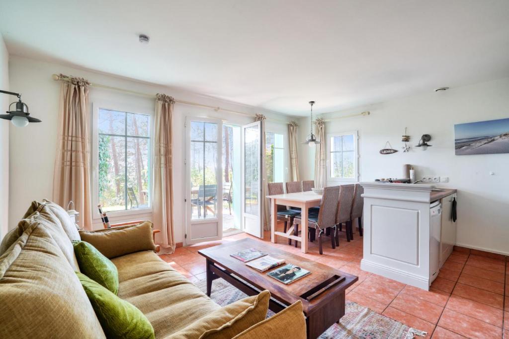 un salon avec un canapé et une table dans l'établissement Les Maisons de Lacanau les Pins - maeva Home - Maison 3 pièces 8 personnes - Prestige MAE-2061, à Lacanau