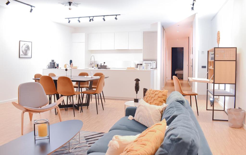 sala de estar con sofá azul y cocina en R213 Residences Botanique, en Bruselas