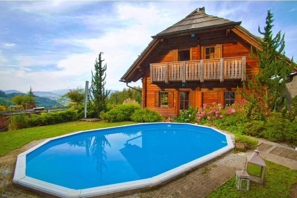 una casa con piscina di fronte a una casa di Chalet Podgorje With Pool a Slovenj Gradec