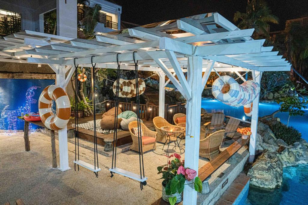 a white pergola sitting next to a pool at Yoho Beach Resort Kenting in Hengchun