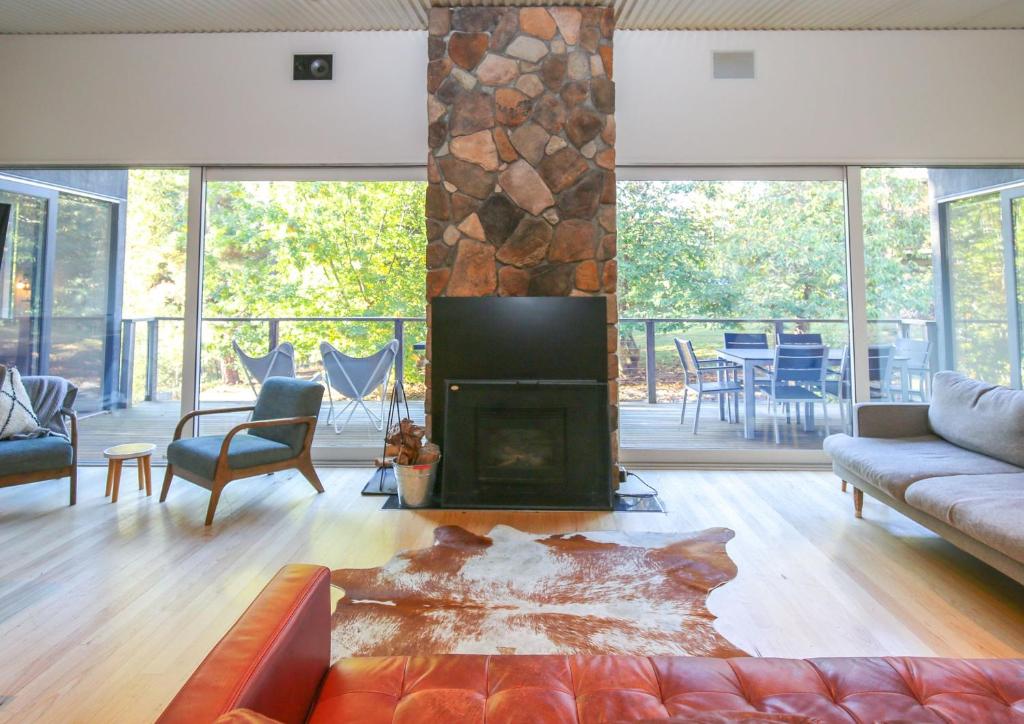 a living room with a fireplace and a couch at Hygge in Harrietville