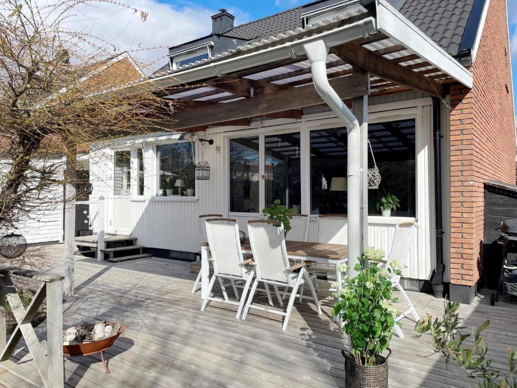een patio met witte stoelen op een houten terras bij Holiday home SPÅNGA in Stockholm