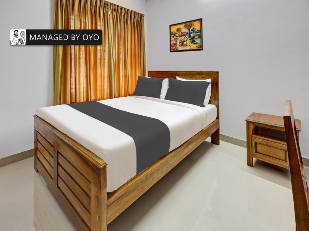 a bed in a bedroom with a wooden frame at OYO Timber Near Lulu Mall in Trivandrum