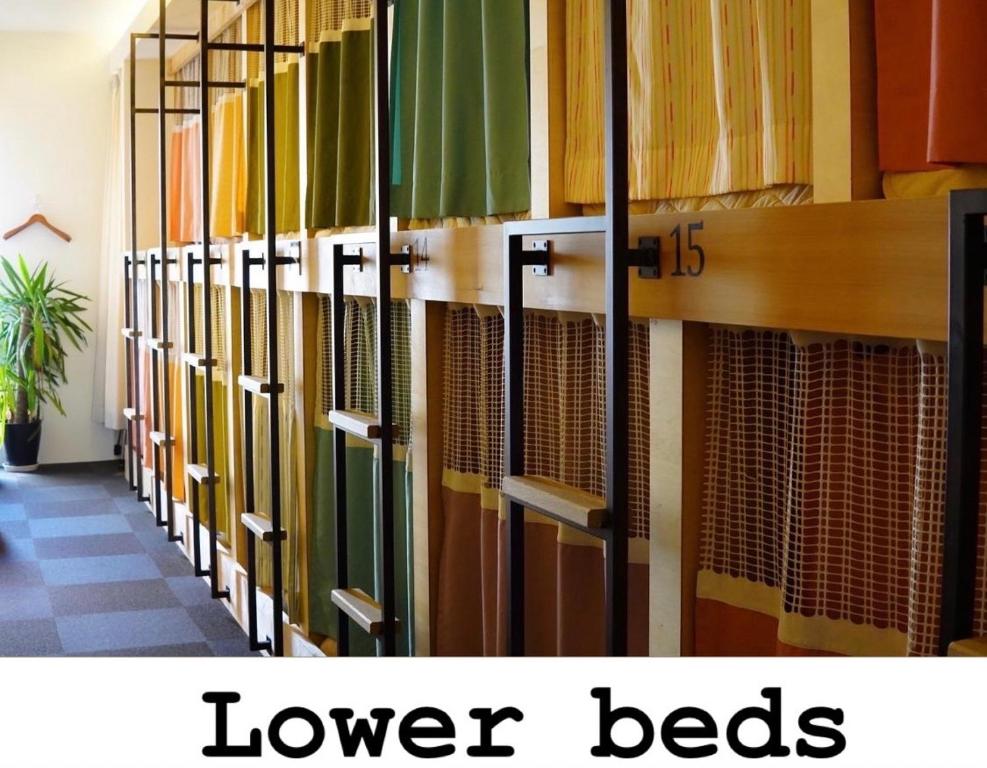 a row of book shelves in a library with the words lower beds at Guesthouse COCO Hiroshima (Female Only) in Hiroshima