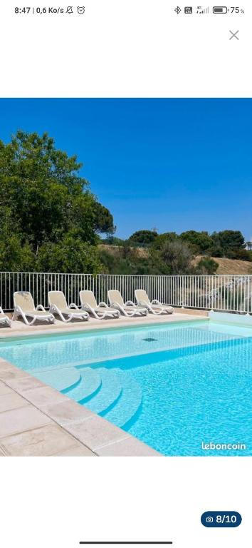 - une piscine avec des chaises longues à côté d'une clôture dans l'établissement Vacances en Provence aux portes de Cassis, à Carnoux-en-Provence
