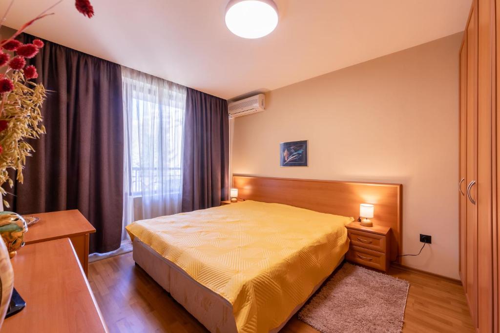 a bedroom with a yellow bed and a window at Golden Sands 1BD Summer Retreat by Flat Mаnаger in Golden Sands