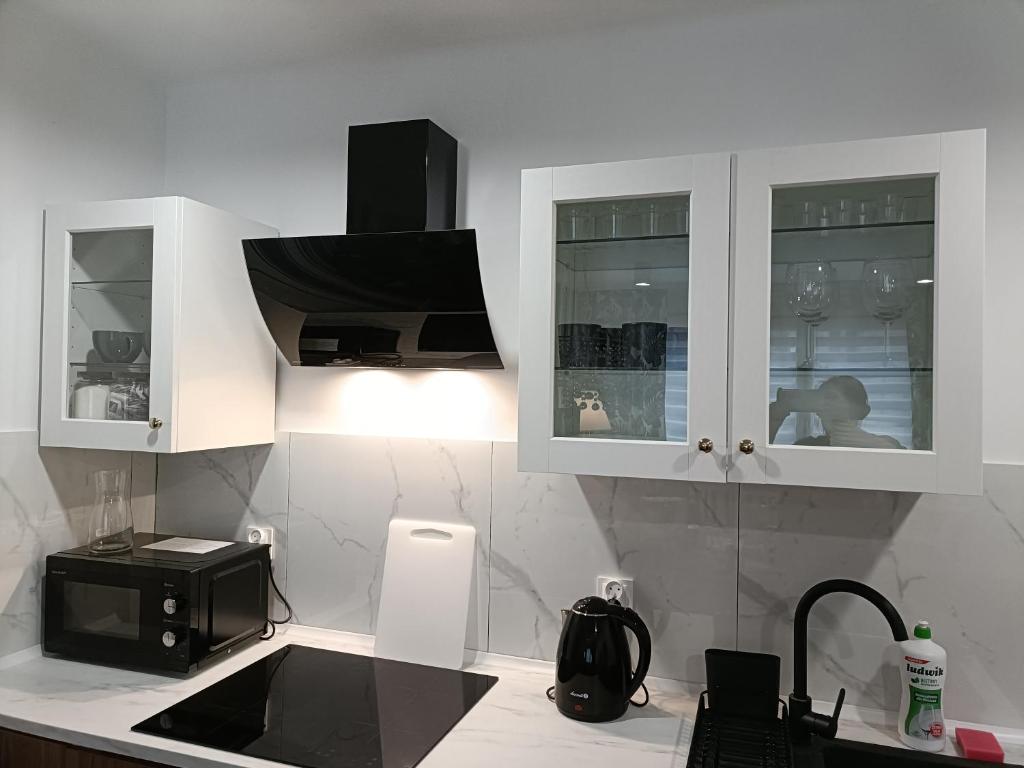cocina con armarios blancos y microondas negro en Tabago Studio 19, en Kędzierzyn-Koźle