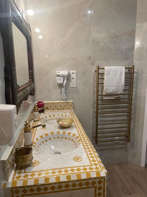 a bathroom with a mosaic sink with a mirror at Suite Orientale Maison de L'église du Couvent in Narbonne
