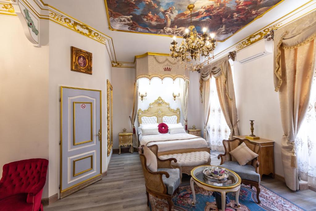 a bedroom with a bed and a chandelier at Suite Royale Maison de l'église du couvent in Narbonne