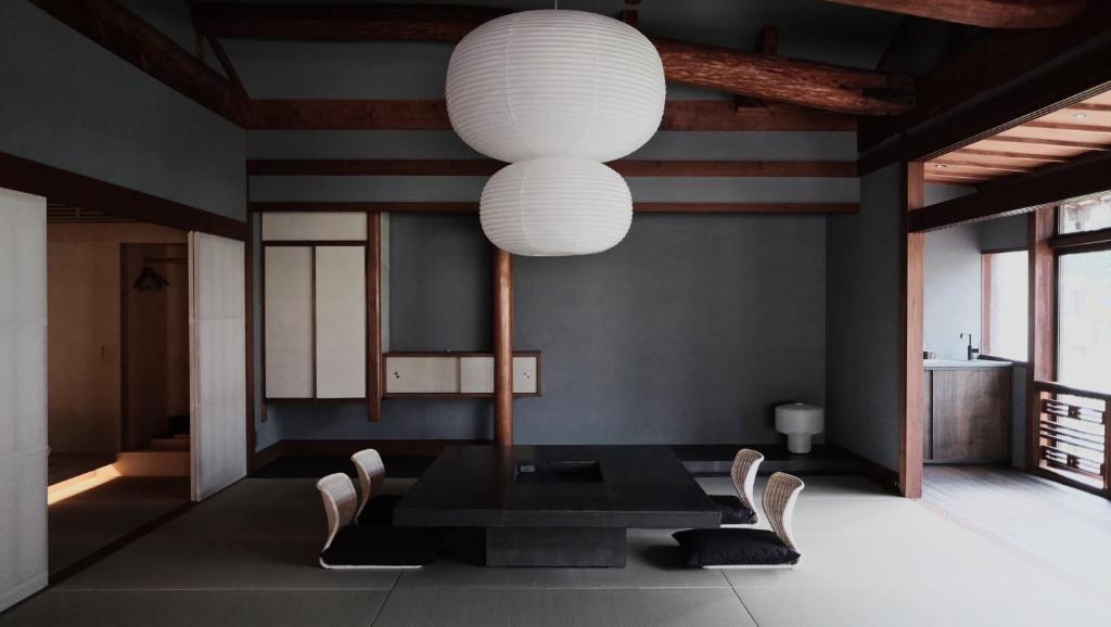 a dining room with a table and a large light fixture at Kobayashiya -Kinosaki Onsen- in Toyooka