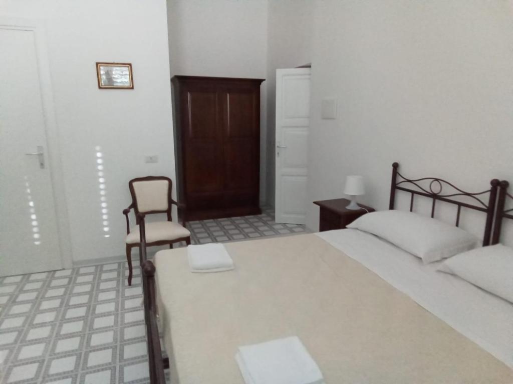 1 dormitorio con 1 cama grande y 1 silla en LOCANDA DEI FOLLI, en Roccamonfina