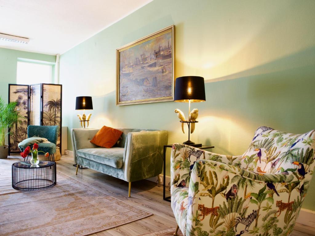 uma sala de estar com duas cadeiras e um sofá em Apartmenthaus Hamburg Les Jardins em Hamburgo