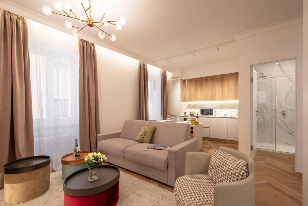 ein Wohnzimmer mit einem Sofa, Stühlen und einem Tisch in der Unterkunft Novos Emerald - Happy Rentals in Lugano