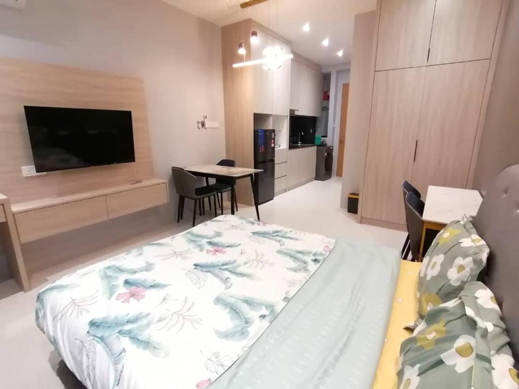 a room with a bed and a television and a table at Simple Nice Stay @ Riverine Diamond Petanak in Kuching