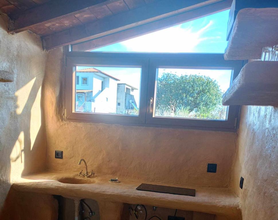 a bathroom with a sink and a window at Homatino Eco Smart in Nea Moudania