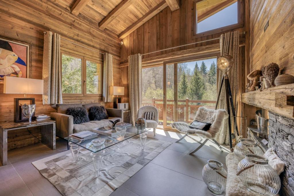a living room with a stone fireplace and wooden walls at Appartement Chalet à Megève in Megève