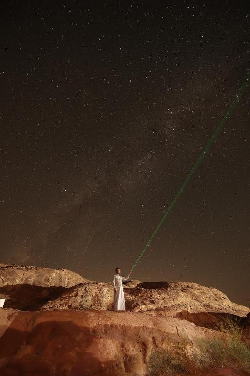 a man flying a kite in the night sky at Star World Camp in Wadi Rum