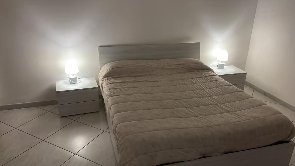 una camera con un letto e due comodini con lampade di Flora House a Brindisi