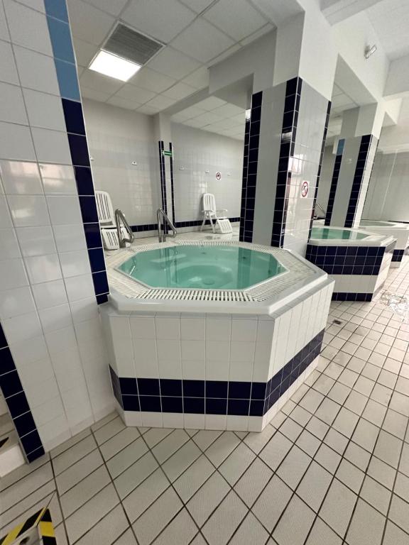 a jacuzzi tub in a bathroom with a mirror at AL-DOM apartamenty Grey 112 Olymp in Kołobrzeg