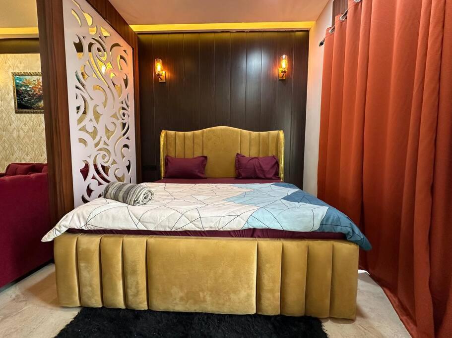 a bedroom with a bed with a gold head board at VelvetHouz Luxury Studio Apartment In Noida in Ghaziabad