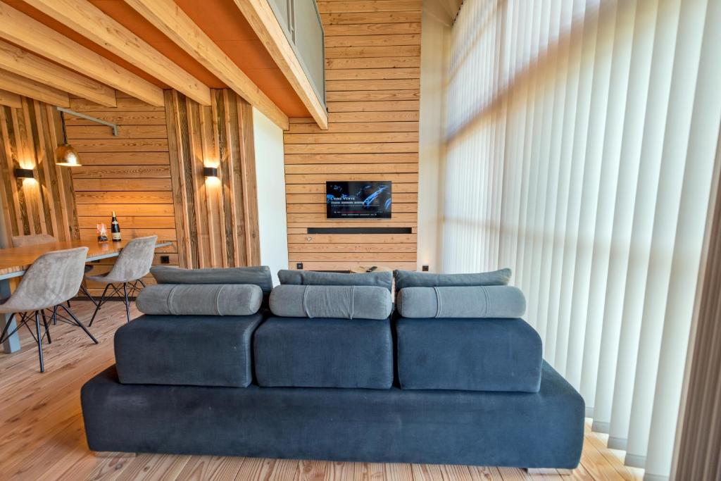 a living room with a blue couch and a table at le petit ballon in Ventron
