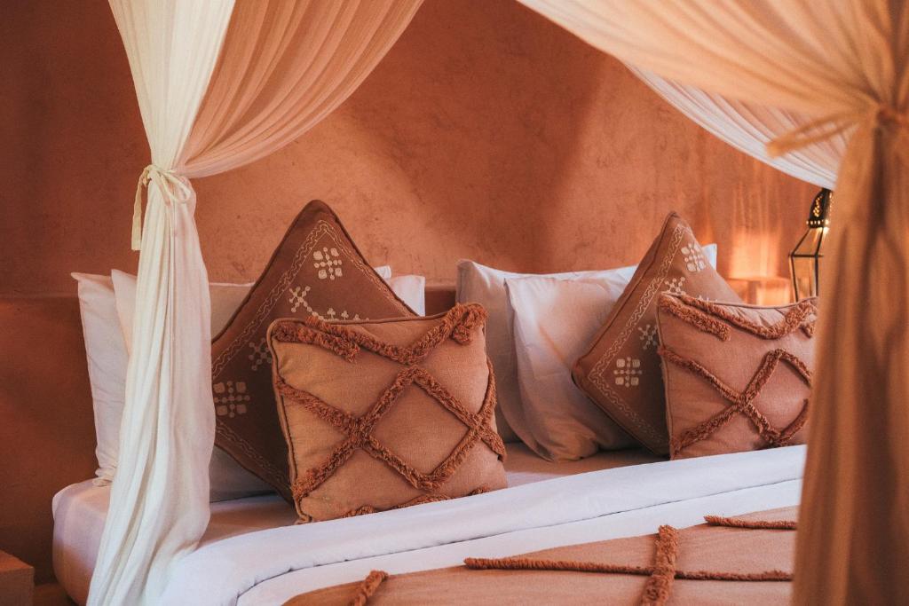 a bedroom with a bed with white and brown pillows at Terra Cottages Bali in Uluwatu