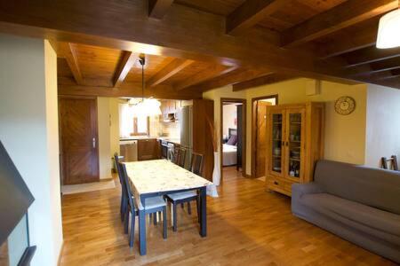 a living room with a table and chairs and a couch at Duplex el Pla de la Tour in Latour-de-Carol