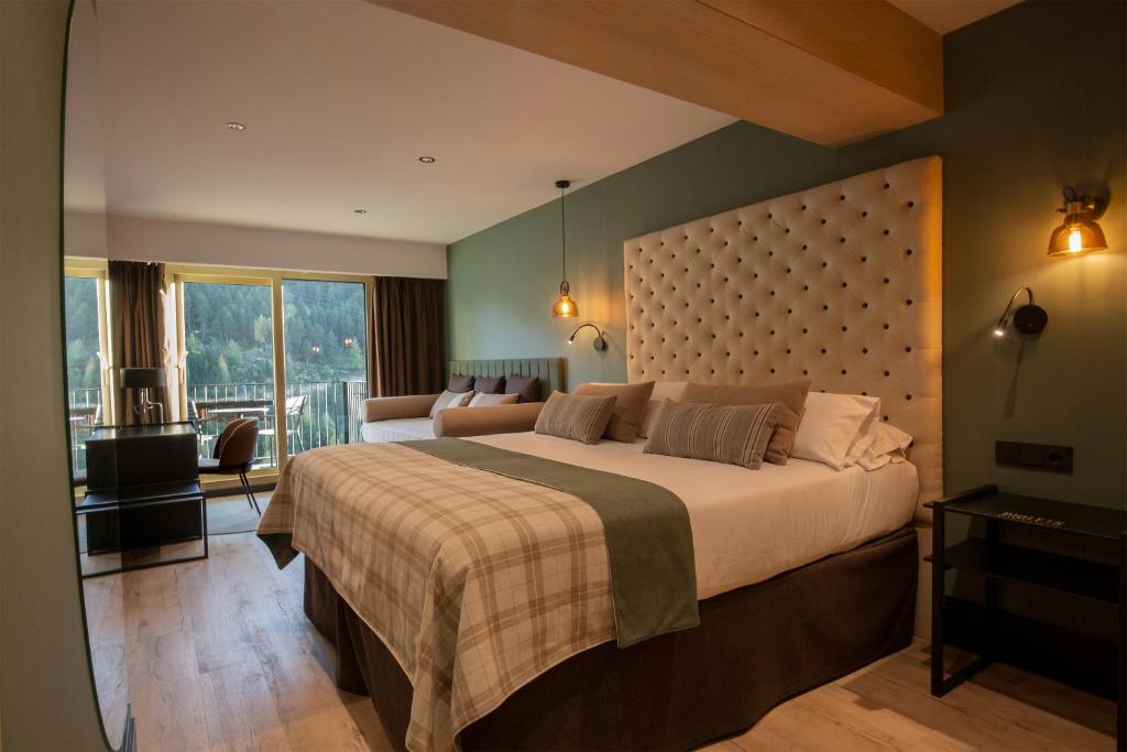 1 dormitorio con 1 cama grande y balcón en Hotel Piolets Soldeu Centre, en Soldeu