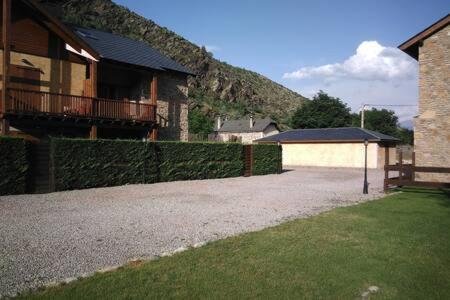 a house with a gravel driveway next to a building at Duplex el Pla de la Tour in Latour-de-Carol