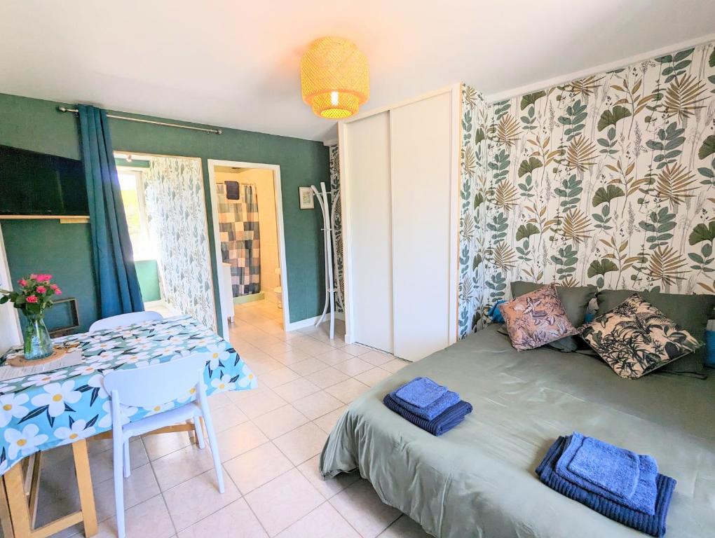 ein Schlafzimmer mit einem Bett und einem Tisch mit blauen Handtüchern in der Unterkunft Studio Silhem in Saint-Germain-les-Belles