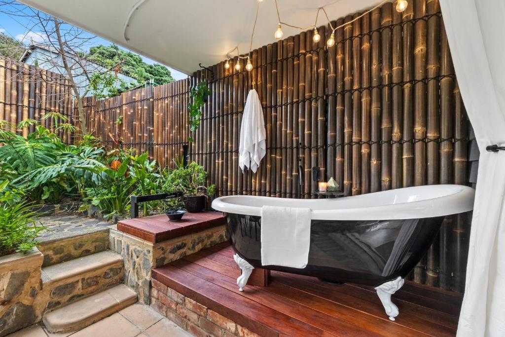 a bathroom with a bath tub on a wooden deck at Mrs Percivals heritage luxury and romance with outdoor deep soak tub in Victor Harbor