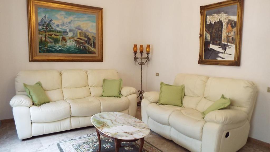 uma sala de estar com dois sofás brancos e uma mesa em Sartinicco Apartment em Montepulciano