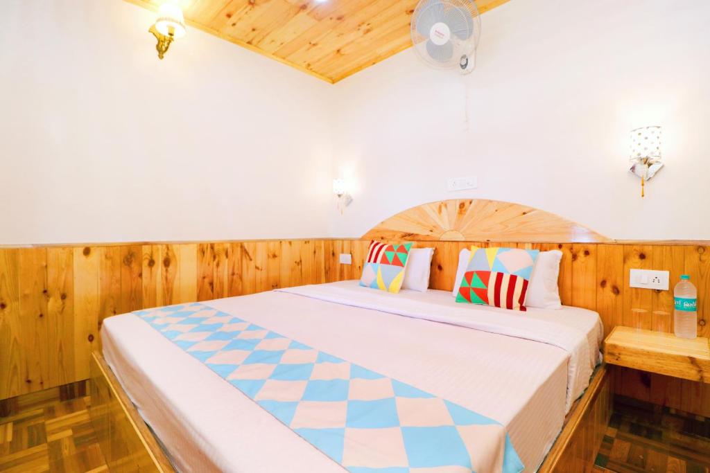 1 dormitorio con 1 cama grande y paredes de madera en OYO Flagship 81046 Ritik Home Stay en Shimla