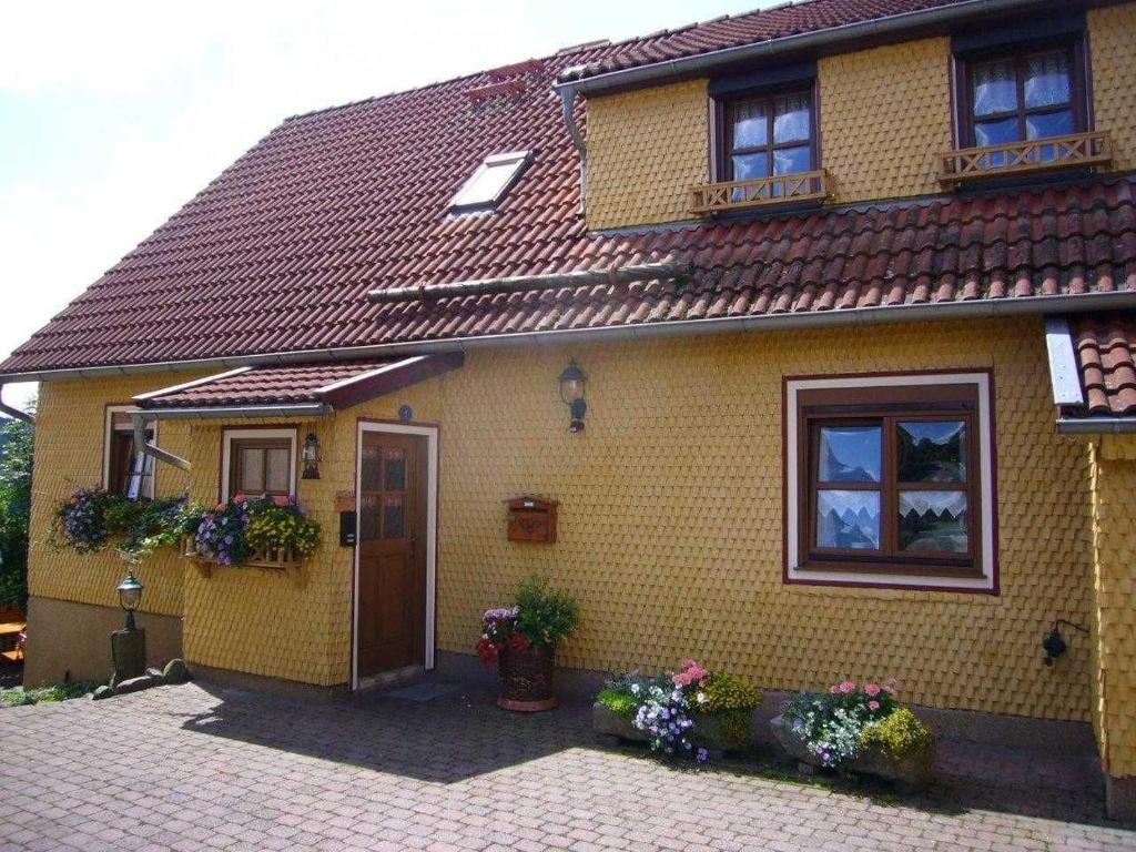 una casa de ladrillo amarillo con puerta y ventanas en Ferienwohnung Landidylle, en Birx