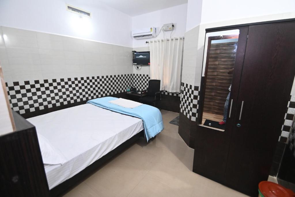 a small bedroom with a bed and a bathroom at Canara Vibes in Māvalli