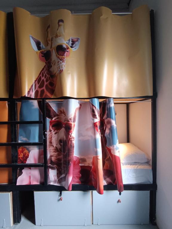 uma cama com uma girafa e um bicho de peluche em Tribes - Upscale City Centre Hostel em Rodes