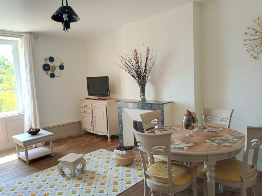 uma sala de jantar com uma mesa e cadeiras e uma televisão em Le Clos de Soulages gîte 2 pers em Palmas