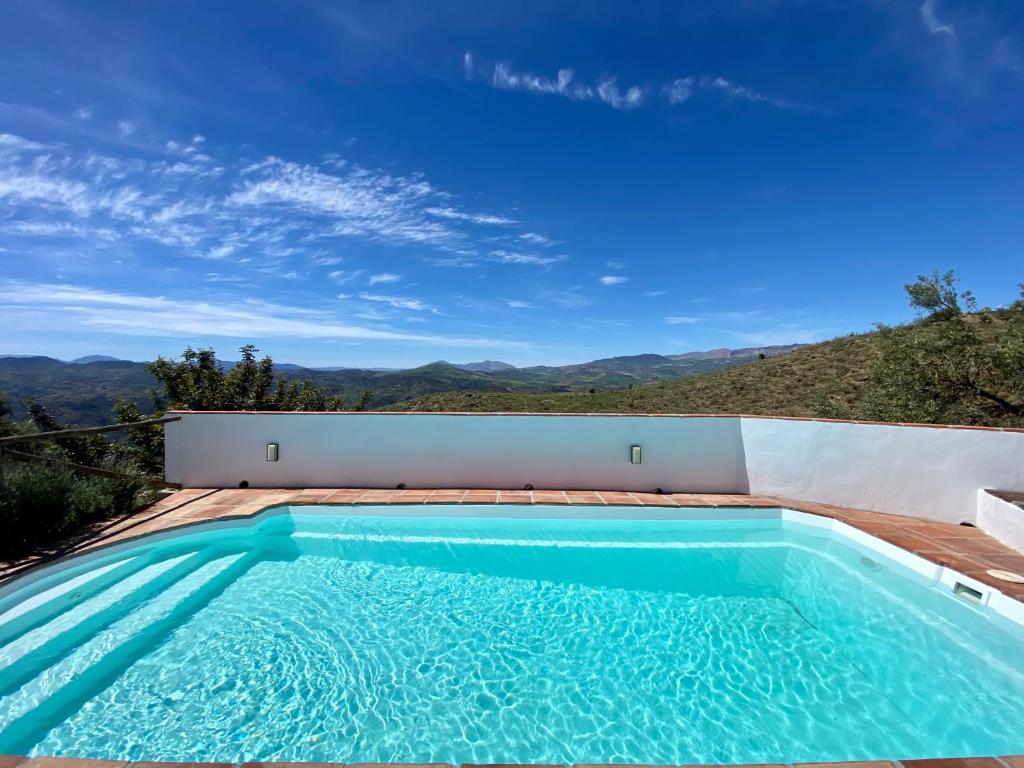 a swimming pool with a view of the mountains at El Cielo, Cortijo en el corazón de las montañas in Málaga