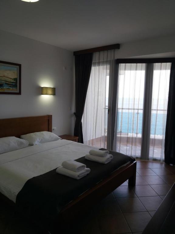 sypialnia z dużym łóżkiem z ręcznikami w obiekcie Apartman AidaLux w mieście Bijela Glavica