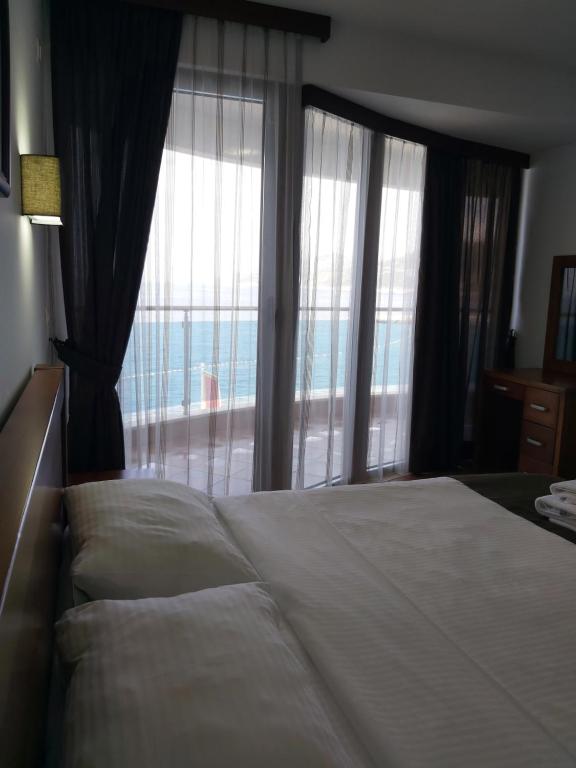 sypialnia z dużym łóżkiem i dużym oknem w obiekcie Apartman AidaLux w mieście Bijela Glavica