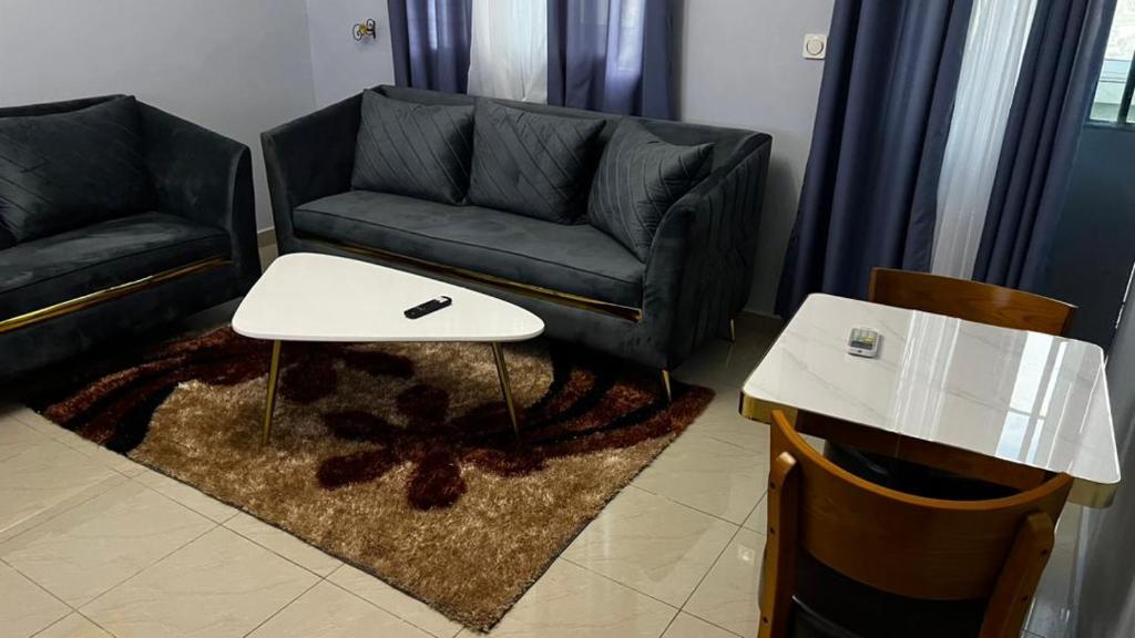 - un salon avec un canapé et une table dans l'établissement Magistral apparts, à Yaoundé