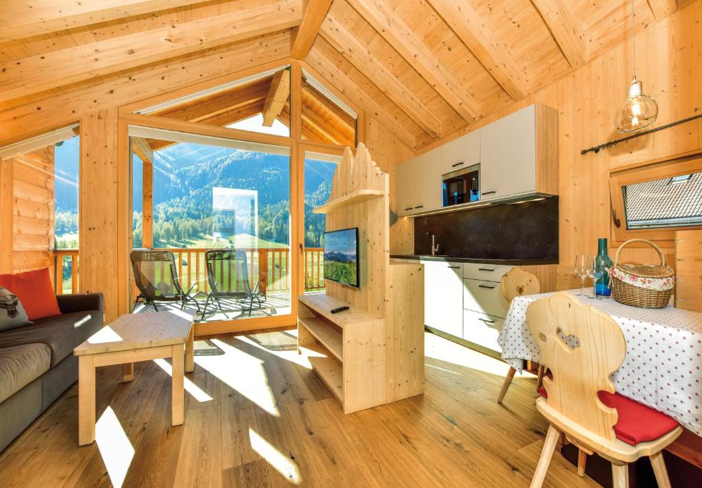 a log cabin with a living room and a table at Stabinger Hof in Sesto
