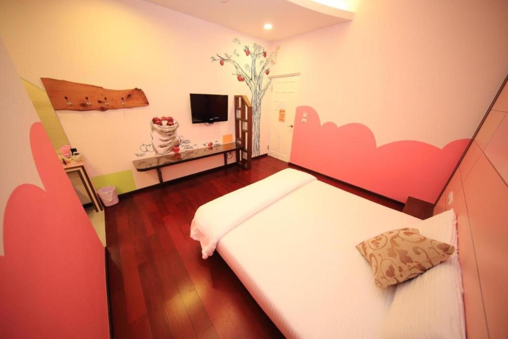 a bedroom with a bed with a pink cloud painted on the wall at Haoho in Xiaoliuqiu
