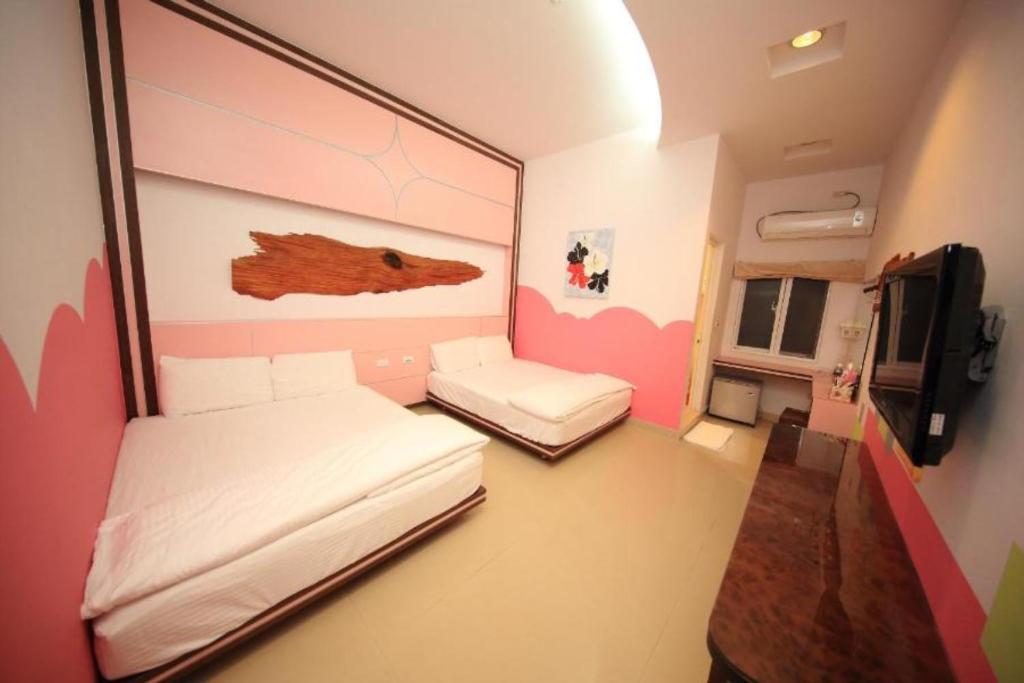 a small room with two beds and a tv at Haoho in Xiaoliuqiu