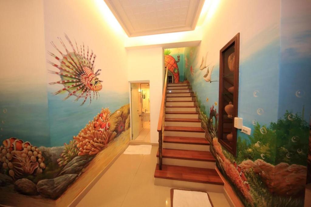 a hallway with a staircase with an aquarium mural at Haoho in Xiaoliuqiu