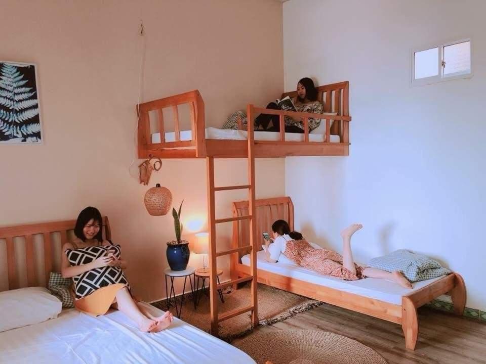 Duas raparigas sentadas em camas num quarto com beliches em Peaceful house em Vung Tau