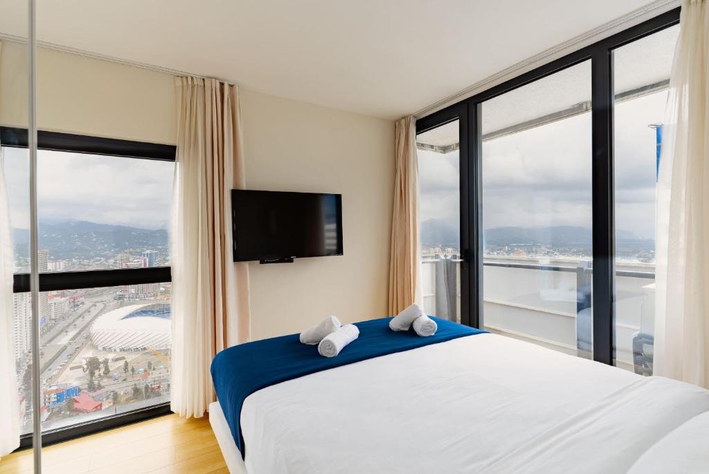 a bedroom with a bed and a large window at Elegance Sea View Aparthotel In Orbi City Batumi in Batumi