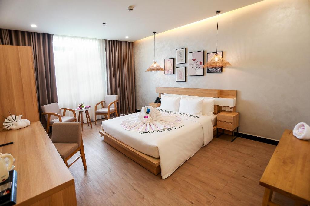 a hotel room with a bed with a flower on it at The Hub by Hotel Academy Phu Quoc in Phú Quốc